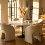 Rectangular Carrara marble dining table with walnut legs in a sunlit dining room